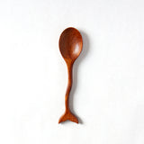Wooden fish tail shaped spoon on a white background