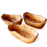 Three rustic handcrafted wooden bowls with natural live-edge bark, displayed on a clean white background.