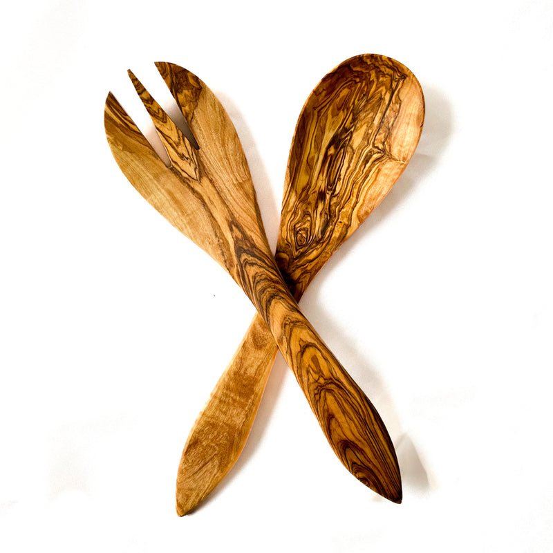Crossed set of wooden salad servers on a white background