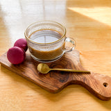 Coffee, Macaroons and gold spoon on paddle board