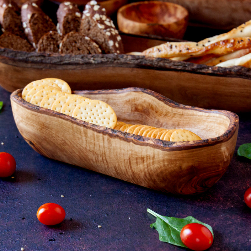 wood cracker basket with crackers and bread on a dark background