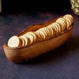 Wooden cracker basket filled with crackers on a dark background