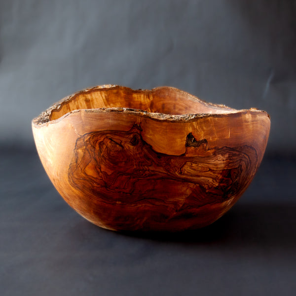 Extra Large Olive Wood Serving Bowl with Live Edge on black background