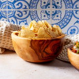 Wooden bowl with tortilla chips on a blue tile background