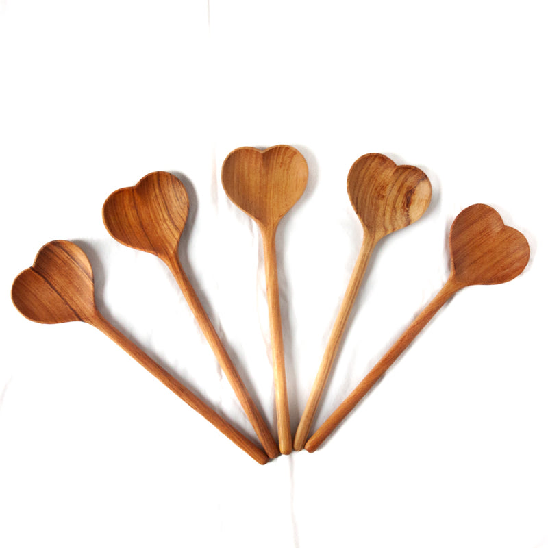 Five large wooden heart shaped spoons with slight variation of wood grain color, all on a white background