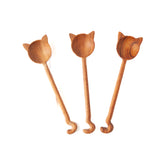Three cat spoons of varying shades of wood colors on a white background