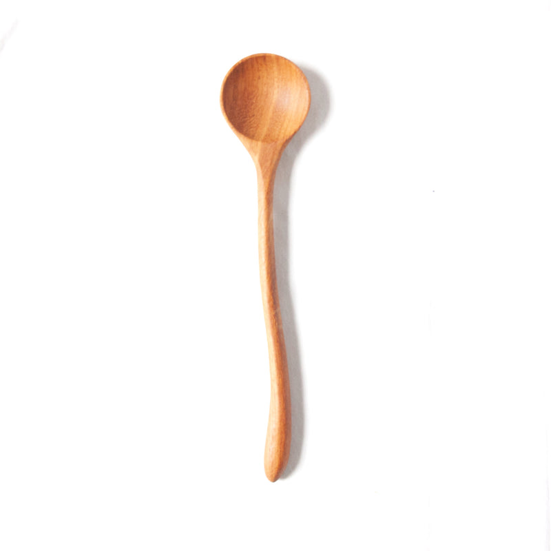 single curvy hand carved wooden spoon on a white background