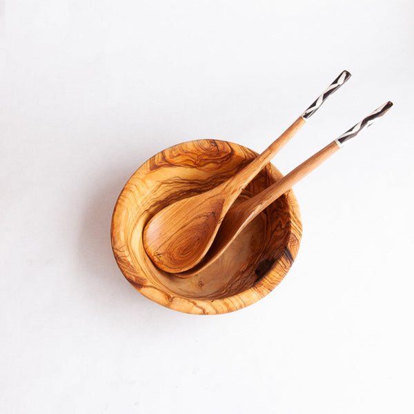 Wood salad servers in a wooden bowl