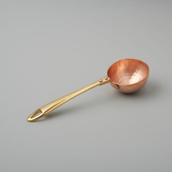 Copper and Brass Coffee Scoop on a neutral background