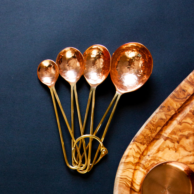 Copper Measuring Spoons fanned out on a black background