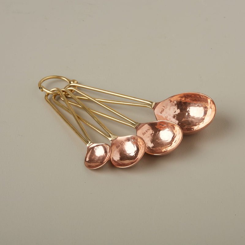 Copper and Gold Measuring Spoons on a neutral background