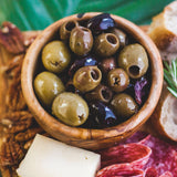 Small wood bowl filled with olives
