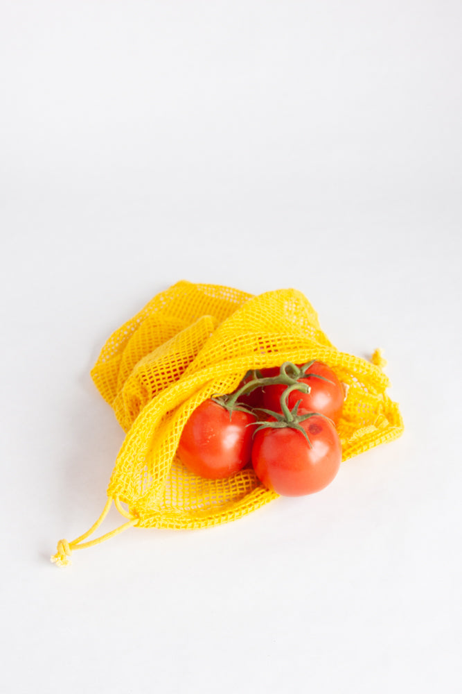 yellow produce bag with red tomatoes