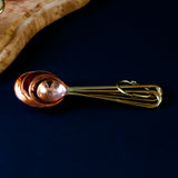 Nested measuring spoons with copper scoops and brass handles