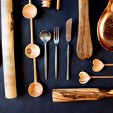 Flat lay of silverware and olive wood utensils