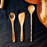 Various olive wood utensils on black tablecloth